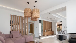 Un salon moderne avec un canapé d’angle, une table basse en bois et une grande fenêtre qui laisse entrer la lumière naturelle.
