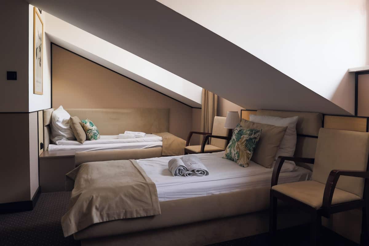 Una habitación de hotel con dos camas, un escritorio y una silla.