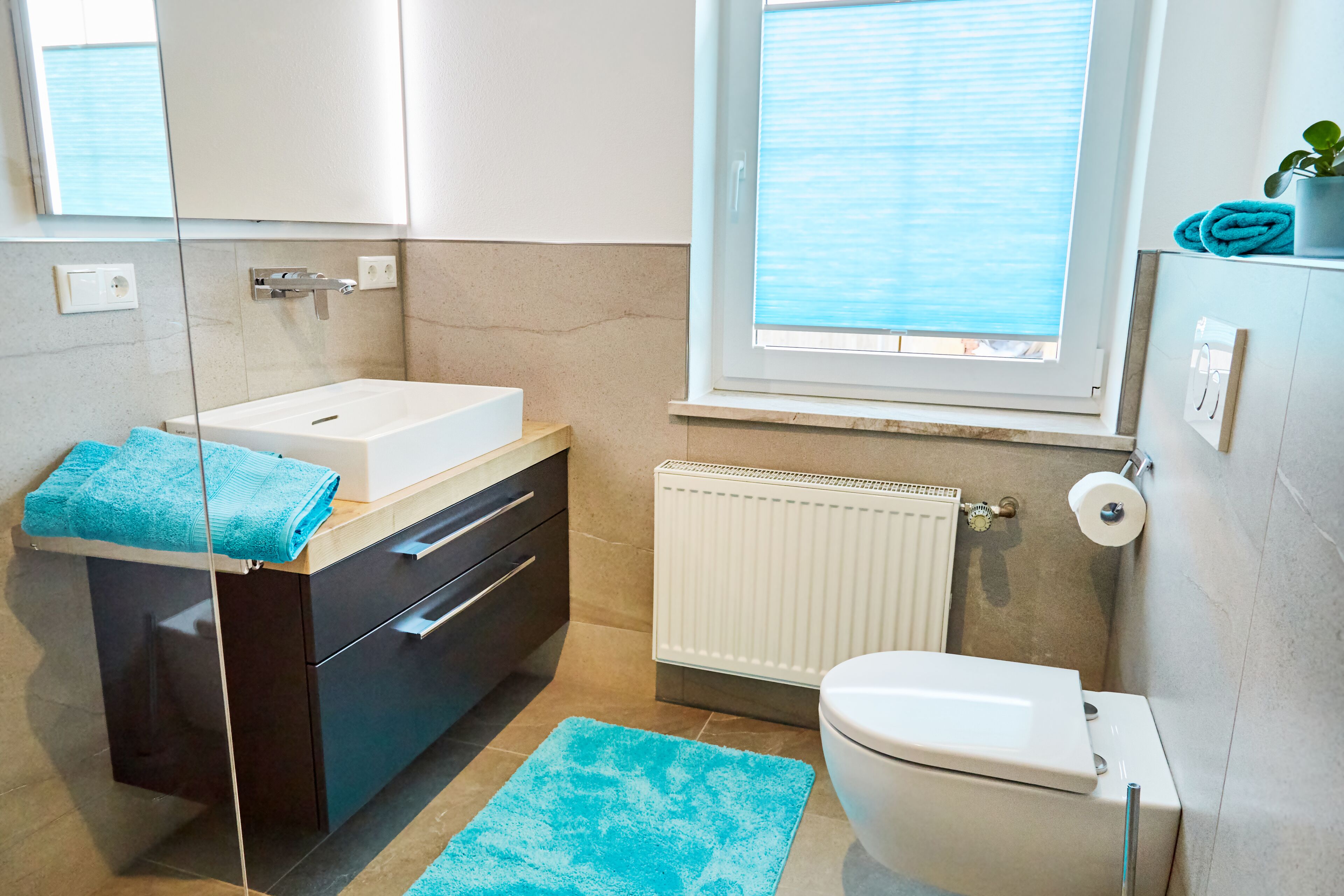 Et moderne badeværelse med badekar, toilet og et vindue med udsigt.