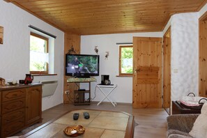 Ein gemütliches Wohnzimmer mit Fernseher, Holzmöbeln und Kamin.