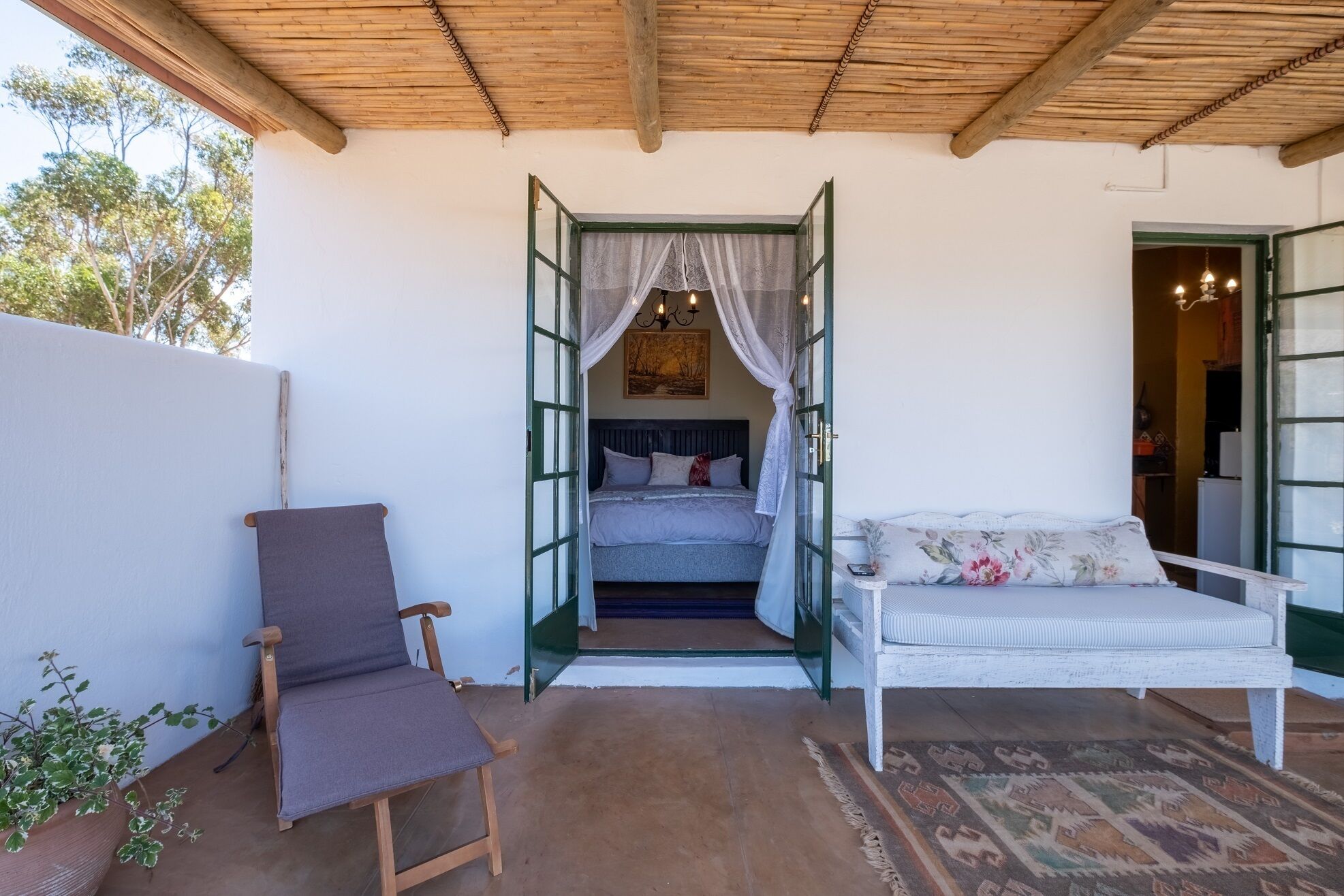 Un dormitorio con cama, una silla y un sofá.