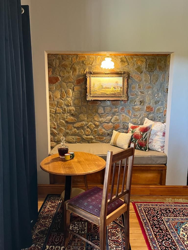 Eine gemütliche Sitzecke mit einer Steinwand, einem Holztisch und einer gepolsterten Bank.