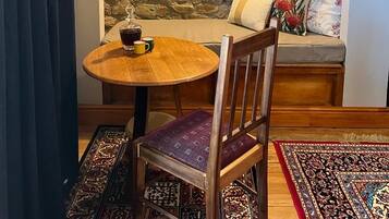 A cozy seating area with a stone wall, a wooden table, and a cushioned bench.