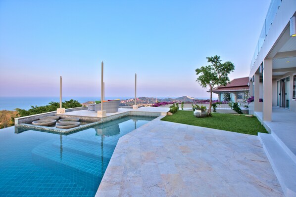 Relax by the ocean-view pool surrounded by lush greenery and modern architecture.
