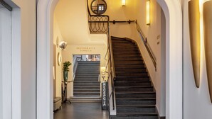 A grand staircase with a metal railing leading to a second floor. - Brovaria (Poznan)