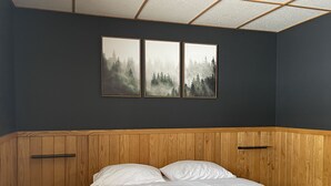 A bedroom with a wooden headboard, a bed with white bedding, and three framed pictures on the wall. - Heart of Houghton! Trails, Shopping & More! (Dodgeville)