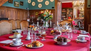 A formal dining room with a red tablecloth, white china, and a variety of desserts and drinks. - Domaine de Chalaniat (La Sauvetat)