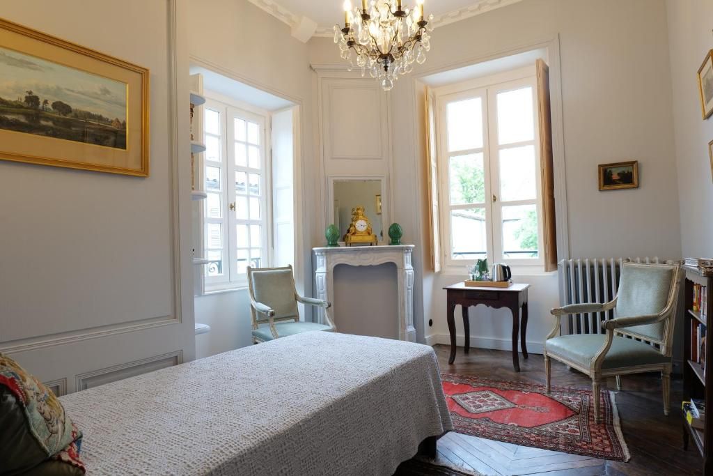 Una habitación con cama, chimenea, sillón y estantería.
