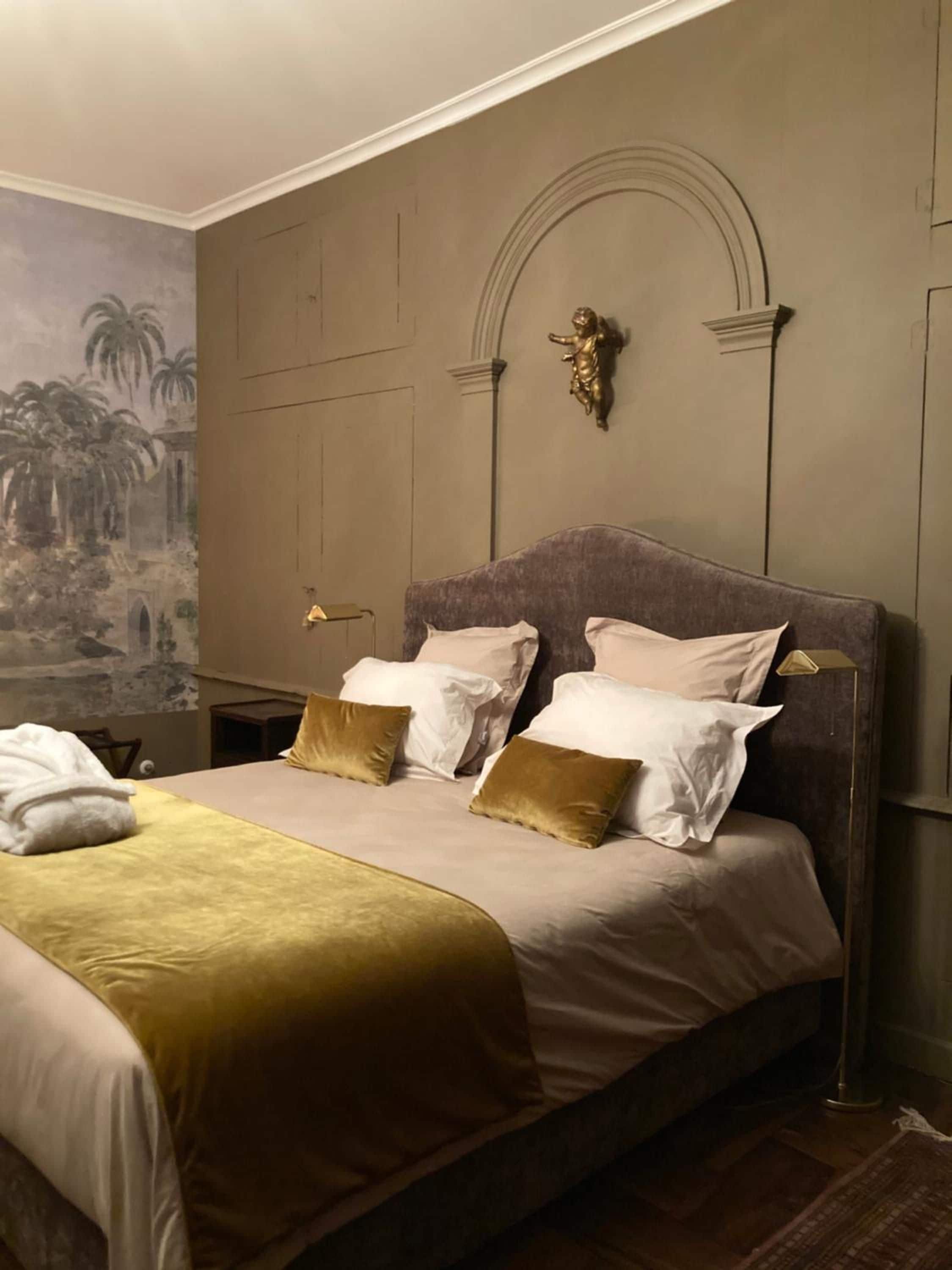 A bed with a headboard, multiple pillows, and a blanket.