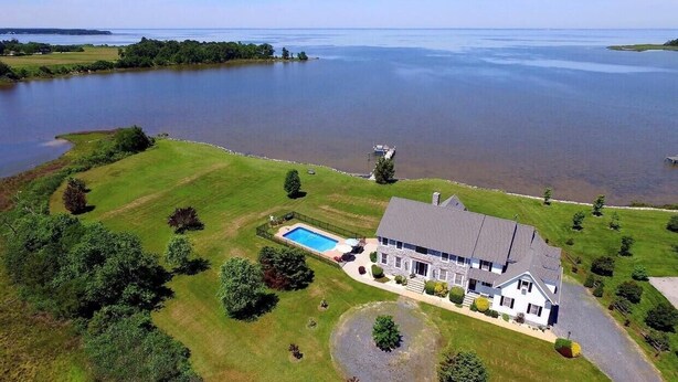 A large house with a swimming pool, surrounded by a well-maintained lawn and a lake. - Minutes from Downtown Cambridge | Private Dock | Pool | Kayaks (Cambridge)