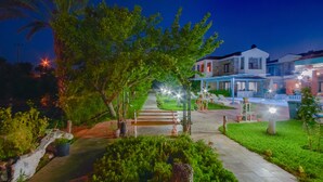 A well-lit pathway leading to a building with a covered outdoor seating area and a pool. - Ekinoks Butik Otel (Datça)