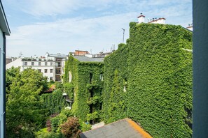 Un edificio cubierto de hiedra verde, con múltiples ventanas y un techo plano.