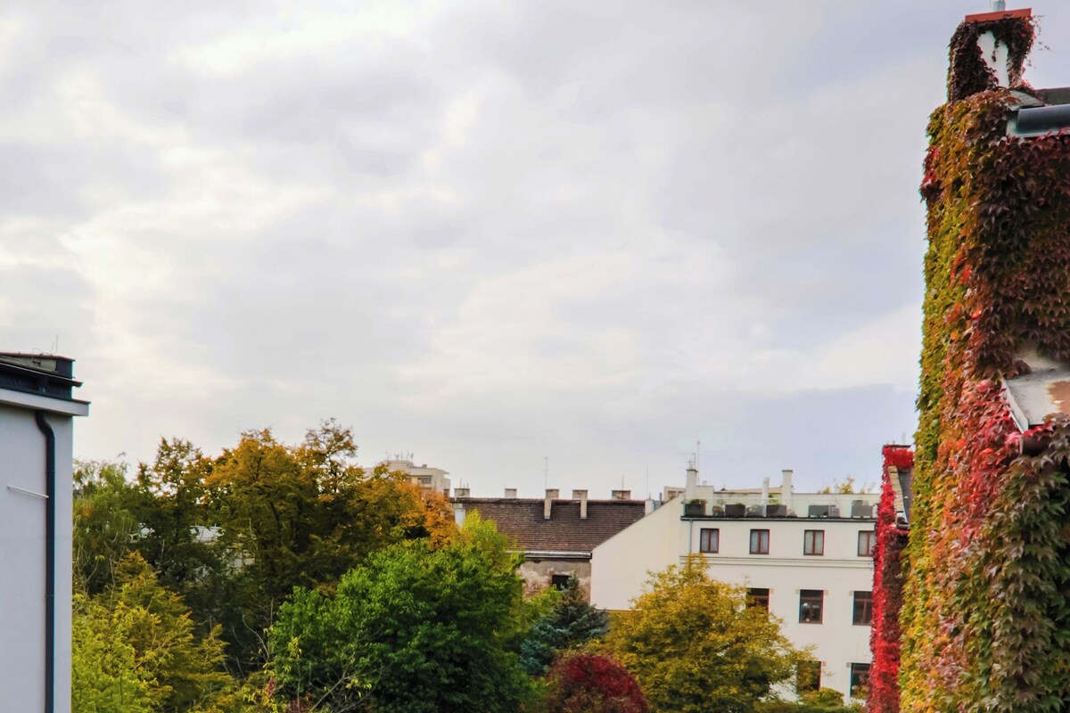 Un jardín en la azotea con follaje denso y vistas a edificios al fondo.