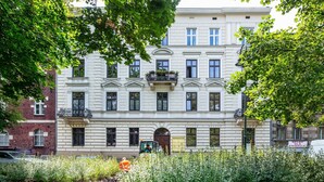 A multi-story building with a classic architectural style, featuring a central entrance with a door and windows on each floor. - Aparthotel Cracovia Residence (Kraków)