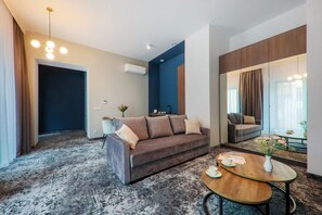 A modern living room with a sofa, a coffee table, and a mirror. - Aparthotel Cracovia Residence (Kraków)
