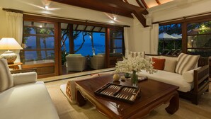 Una sala de estar acogedora con una mesa de centro de madera, un sofá y vistas al océano.