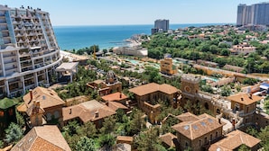 A coastal cityscape with a large cruise ship docked, historic buildings, and a mix of residential and commercial structures. - Rai Apartments (Odesa)