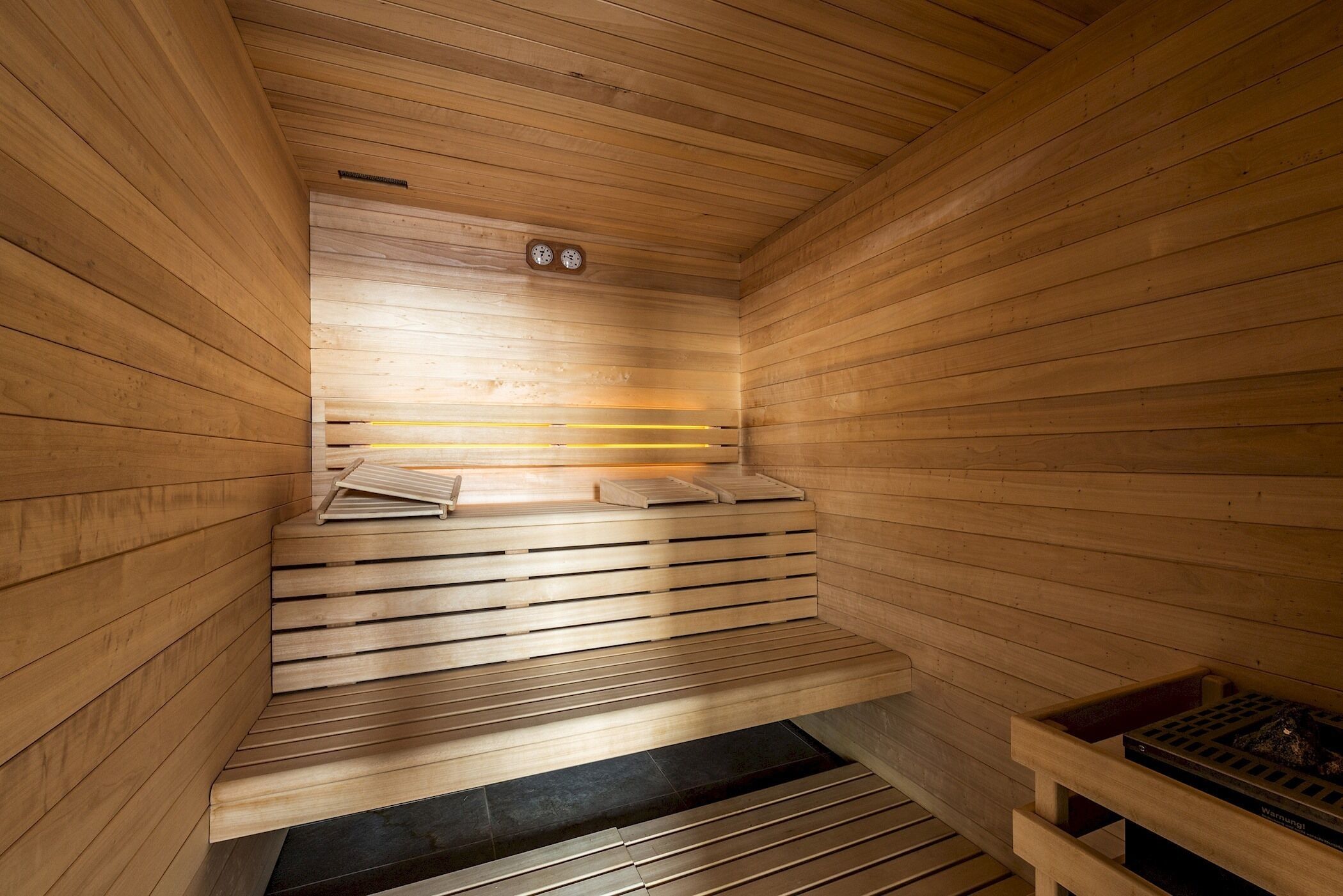Eine Holzsauna mit Bänken und einer Sitzbank.