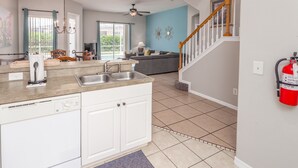 A kitchen with a double sink, white cabinets, and a ceiling fan. - Tuscan Hills-ru1064 (Davenport)