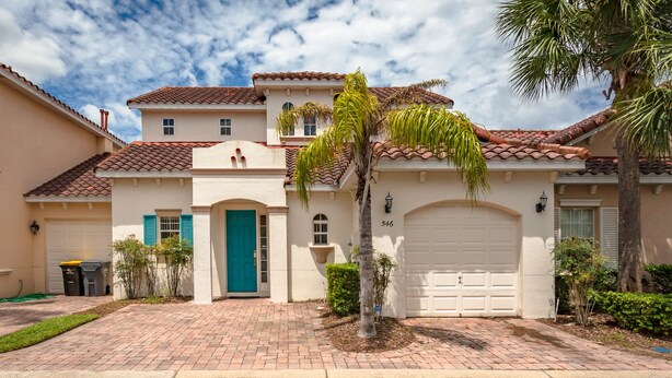 A two-story house with a white facade, red-tiled roof, and a green door. - Tuscan Hills-ru1064 (Davenport)