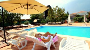 Ein Poolbereich mit Liegestühlen und Sonnenschirmen.
