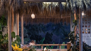 A thatched-roof outdoor seating area with a sign reading "marii".