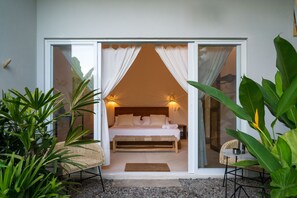 Ein Schlafzimmer mit einem Bett, einer Bank und einem Sessel.