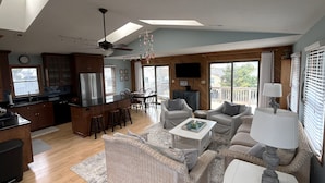 A spacious living area with a kitchen, dining area, and a balcony with a view. - Charming Cottage, South Nags Head, 5 min walk to the beach (Nags Head)
