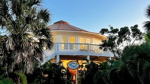 A two-story building with a balcony, surrounded by lush tropical foliage. - Tropical Oasis - Pool w/ Waterfall & Swing Bar (Captiva)