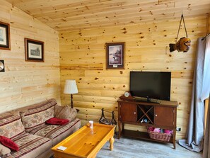 Relax in this inviting room with a comfortable sofa, wooden coffee table, and television.