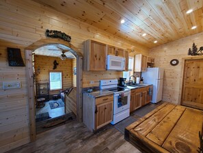 Cozy cabin-style kitchen with a large wooden table and modern appliances.