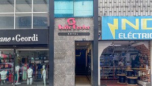 L’entrée d’un hôtel, avec une enseigne indiquant « Suite Center Platino Hotel ».