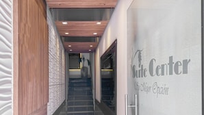 Un couloir avec un mur en bois sur la gauche, un mur texturé sur la droite et un escalier menant à une pièce portant l’inscription « Centre de l’hôtel ».