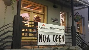 Rakennuksessa on kyltti, jossa lukee: ”SIMMS THE RIVERS EDGE, BOZEMAN, MONTANA” ja ”NYT AUKI”.