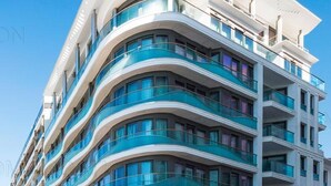 A multi-story hotel with curved balconies and large windows. - 7 Croisette - Luxury Apartment 603 (Cannes)