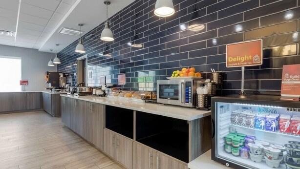 Eine moderne Frühstücksbar mit einer Delikatessentafel, einer Mikrowelle und einer gekühlten Vitrine für Milchprodukte.