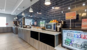 A modern breakfast bar with a deli sign, a microwave, and a refrigerated display of dairy products. - Holiday Inn Express And Suites Choctaw Oklahoma City East by IHG (Choctaw)