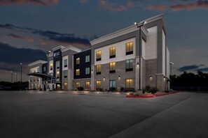 A modern hotel building with multiple floors, large windows, and a covered entrance.