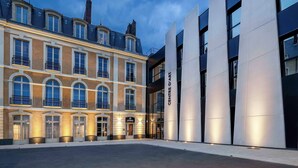 A modern building with a classical facade and a contemporary glass entrance. - Leprince Hotel Spa, BW Premier Collection (Le Mans)