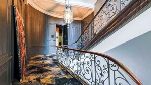 A grand staircase with ornate metal railings and a patterned floor. - Leprince Hotel Spa, BW Premier Collection (Le Mans)