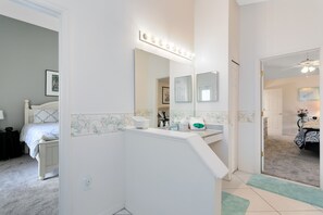 Spacious bathroom with a vanity area, large mirror, and white sink.