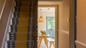 A staircase with patterned steps leading to a dining area with a table and bench. - Fig Tree House, Deal, Kent (Deal)