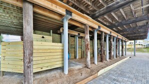 A covered outdoor area with wooden benches and metal poles, likely part of a stable or equestrian facility. - La Anahi - Oceanfront Vacation Rental (St. Augustine)