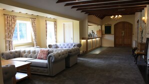 A spacious living room with a large sectional sofa, a wooden coffee table, and a fireplace. - Batch Country House (Weston-super-Mare)