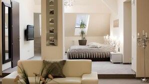 A modern bedroom with a bed, bedside table, and a TV mounted on the wall. - Hotel Evropa Celje (Celje)