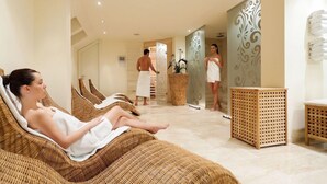 A spa area with reclining chairs, a massage table, and a person attending to a client. - Hotel Evropa Celje (Celje)