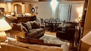 A cozy living room with a sofa, armchair, and a dining table with chairs. - Chalet Suzanne of Helen (Helen)