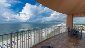 Ein Balkon mit Blick auf Strand und Meer.