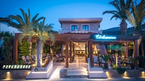 A hotel with a covered outdoor area, palm trees, and a sign that reads "Villa Siona." - Villa Sonia by Estia Adults Only (Hersonissos)