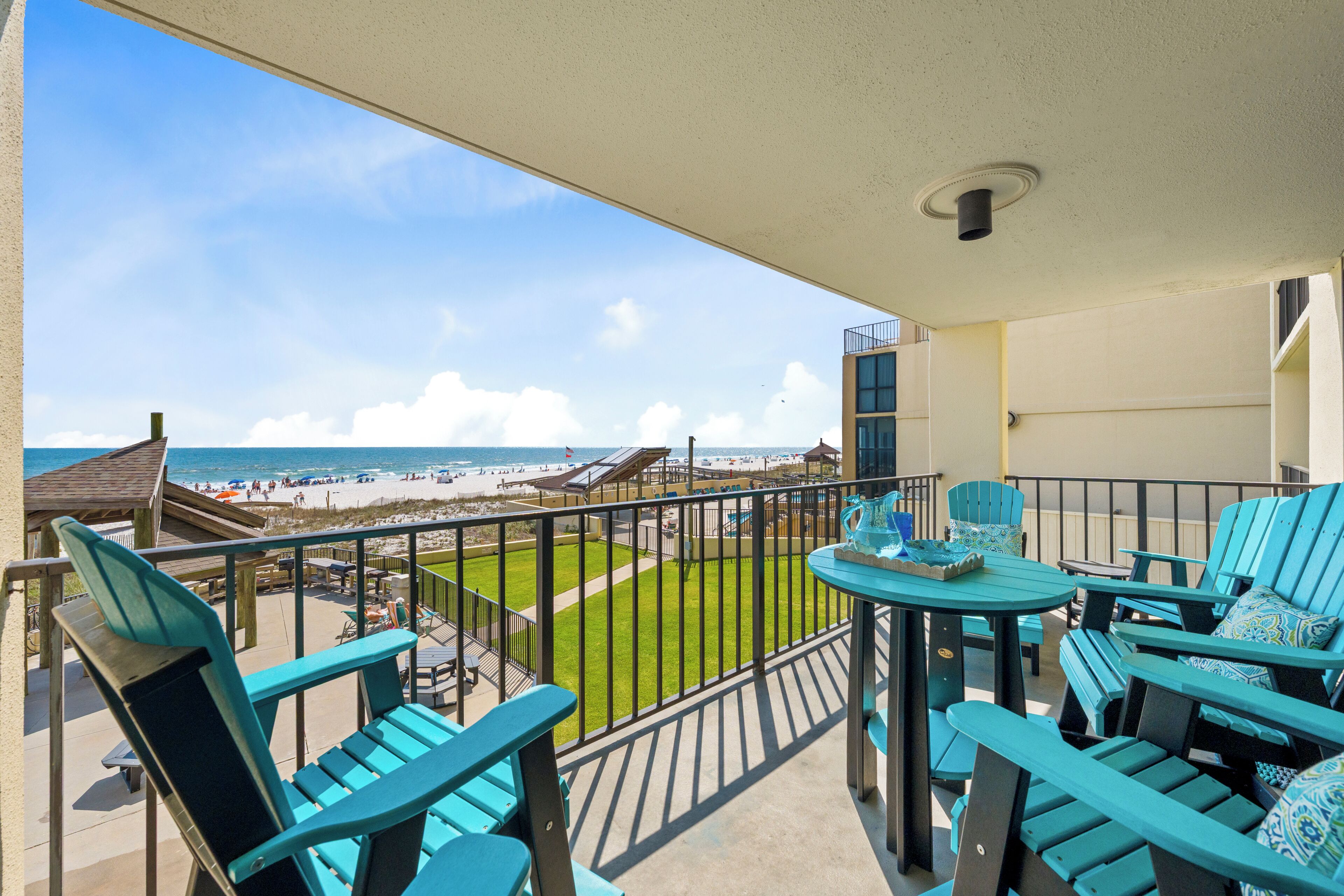 Ein Balkon mit Blick auf den Strand, Sitzgelegenheiten im Freien und ein Poolbereich.